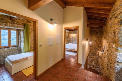 un bagno con vasca e un letto in una stanza di Gerês Country Stays - Sequeiro a Rio Caldo