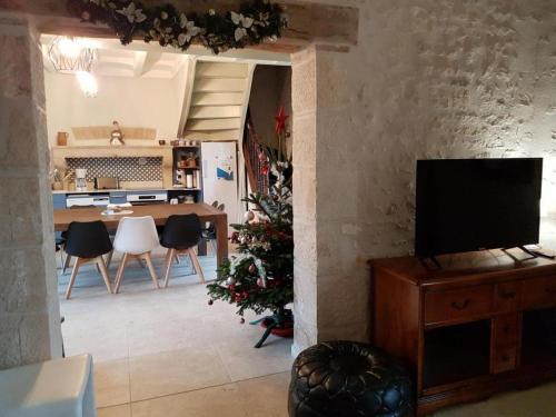 a living room with a television and a christmas tree at Le gite de saint-maixent le petit in Haims