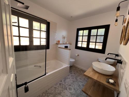 a bathroom with a tub and a toilet and a sink at Villa Torre Cal Sada in Vall-Llobrega