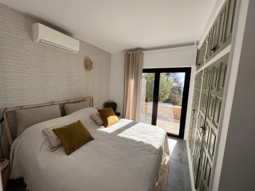 - une chambre avec un lit doté d'oreillers jaunes et d'une fenêtre dans l'établissement Villa Torre Cal Sada, à Vall-llobrega