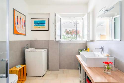 a bathroom with a sink and a white refrigerator at Casa aoom - Casa Vacanze con Sala Yoga e Pilates in San Pietro in Bevagna