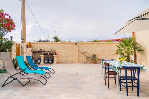 a patio with chairs and a table and an umbrella at Casa aoom - Casa Vacanze con Sala Yoga e Pilates in San Pietro in Bevagna