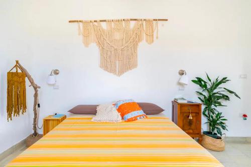 a bedroom with a bed with a yellow and orange striped blanket at Casa aoom - Casa Vacanze con Sala Yoga e Pilates in San Pietro in Bevagna