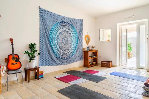 a living room with a large tapestry on the wall at Casa aoom - Casa Vacanze con Sala Yoga e Pilates in San Pietro in Bevagna