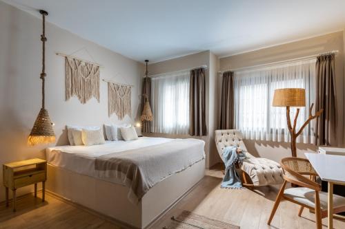 a bedroom with a bed and a table and a chair at Gran Via Alsancak in Konak