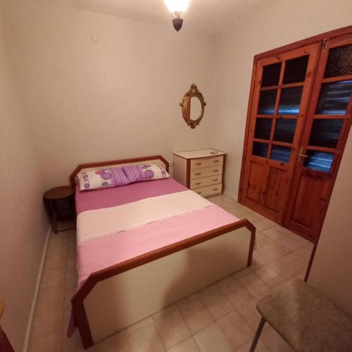 a bedroom with a bed and a dresser and a mirror at Family Holiday House in Aydın