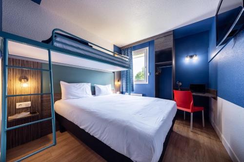 a bedroom with a large bed and a red chair at greet Chartres Est in Chartres