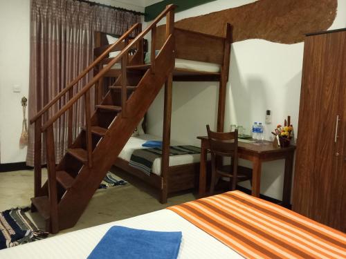 a bedroom with a bunk bed and a desk and a bed at The Nature Park Villa in Sigiriya