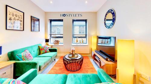 a living room with a couch and a television at Chatham Serviced Apartments by Hosty Lets in Chatham
