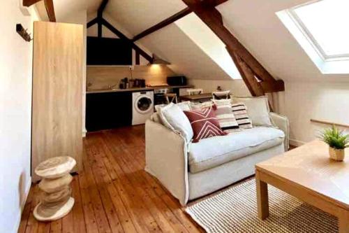 un salon avec un canapé blanc et une cuisine dans l'établissement Le Bali Appart' T1 au centre du Mans, au Mans