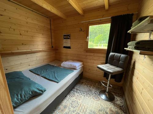 a small room with a bed in a wooden cabin at De Diepen in Milsbeek