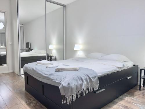 赫爾辛基的住宿－Fabulous Central Apartment Helsinki，白色卧室配有一张带镜子的大床