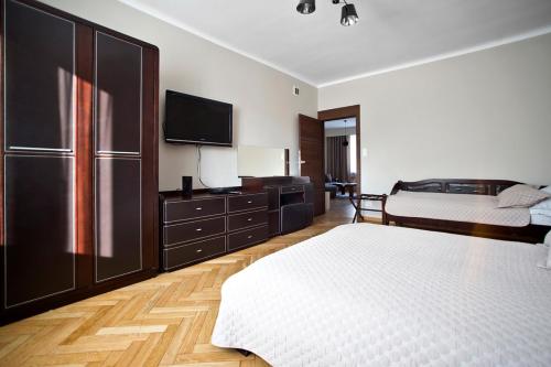 ワルシャワにあるNiepodleglosci Serviced Apartmentsのベッドルーム1室(ベッド2台、薄型テレビ付)