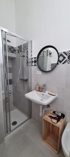 La salle de bains est pourvue d'un lavabo, d'une douche et d'un miroir. dans l'établissement Boemio 30 - B&B Coliving, à Galatina