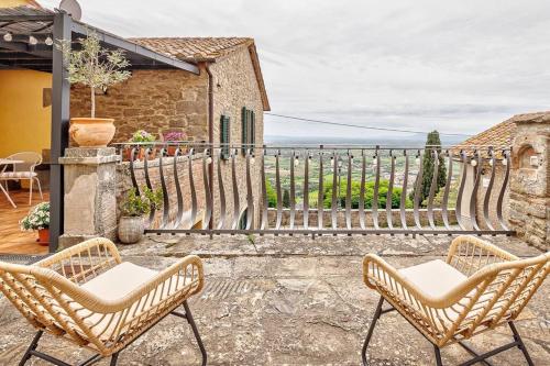 une terrasse avec 2 chaises et une clôture dans l'établissement Il Giardino di Adele - Together in Tuscany, à Cortone