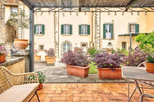 un patio extérieur avec des plantes en pot et un bâtiment dans l'établissement Il Giardino di Adele - Together in Tuscany, à Cortone