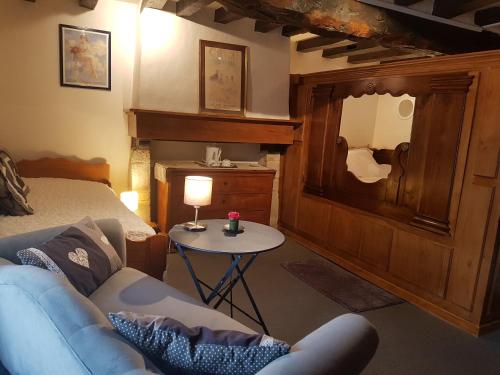 a room with a couch and a table with a mirror at Le Café du Village - Bar à cocktails & à Ambiance in Lohéac