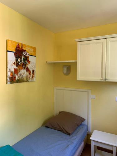 a bedroom with a bed and a white cabinet at Appartement Village P&V domaine du golf Pont Royal Provence avec PARC AQUATIQUE in Mallemort