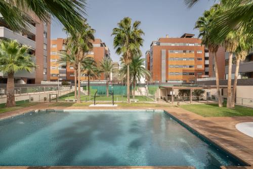 una piscina vacía con palmeras y edificios en EnjoyGranada EMIR 3F - POOL, GYM & Free Parking en Granada