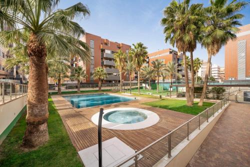 una piscina con palmeras en un parque en EnjoyGranada EMIR 3F - POOL, GYM & Free Parking, en Granada