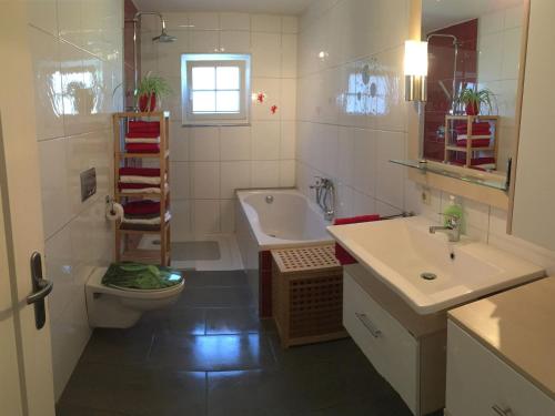 a bathroom with a toilet and a sink and a tub at Ferienwohnung Fritz in Sigmarszell