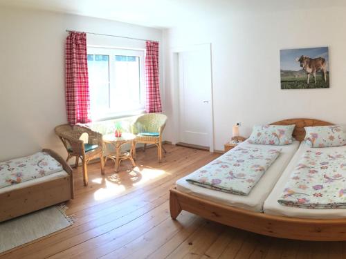 a bedroom with two beds and a table and chairs at Ferienwohnung Fritz in Sigmarszell