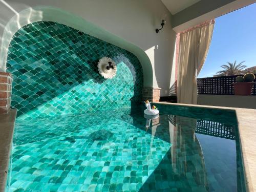 een zwembad met een blauwe tegelvloer en een zwembad bij Chimera Apartments & Suites in Marrakesh