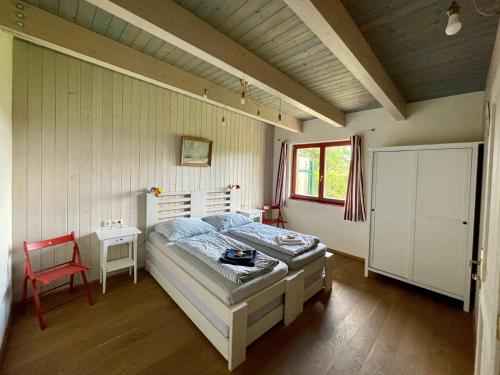 a bedroom with a bed and a red chair at Apartmány Modřínový Dům in Horní Planá