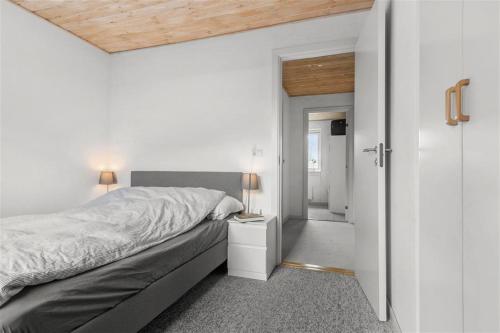 1 dormitorio con 1 cama y puerta que da a un pasillo en House near public transport, en Lystrup