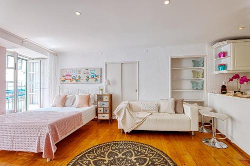 a white bedroom with a bed and a couch at InLoveApartments - Alfama Balcony in Lisbon