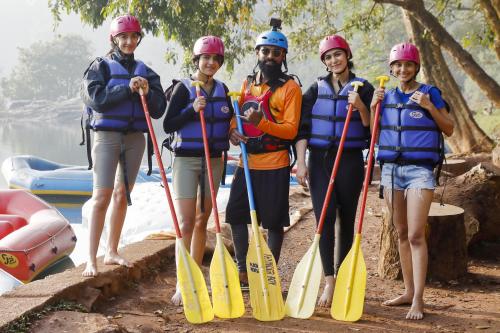 a group of people on a raft on a river at Whistling Woodzs Resort in Dandeli