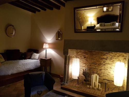 a living room with a fireplace and a mirror at Le Café du Village - Bar à cocktails & à Ambiance in Lohéac