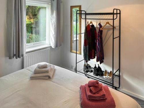 a bedroom with a bed with a rack of clothes at Burn View in Ryton