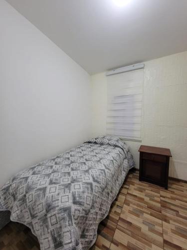 Un dormitorio con una cama y una mesa. en Hostal Pura Vida en Santiago