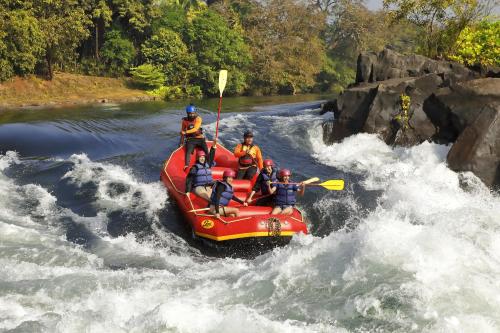 a group of people on a raft in a river at Whistling Woodzs Resort in Dandeli