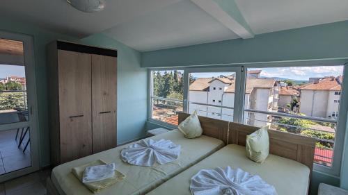 a room with a bed and a large window at Prima Vera Hotel in Primorsko