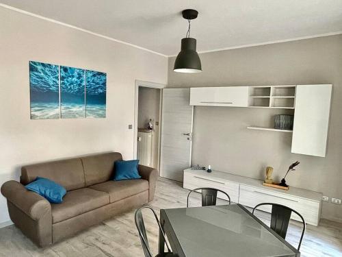 een woonkamer met een bank en een tafel bij BILOCALE CONFINE LOANO-BORGHETTO 250mt dal mare in Borghetto Santo Spirito