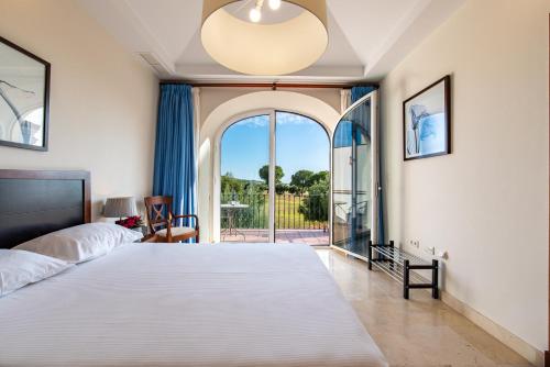 a bedroom with a large bed and a large window at Arcos Gardens Sol Rent Golf in Arcos de la Frontera