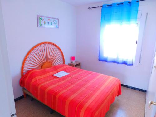 1 dormitorio con 1 cama con edredón de rayas rojas en GMID IMMO Apartment Mas Oliva, en Roses
