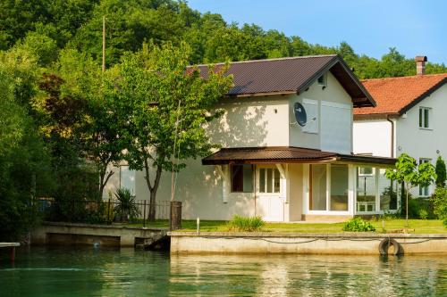 una casa junto a un cuerpo de agua en Vikendica Gorica-Jablaničko jezero, en Konjic