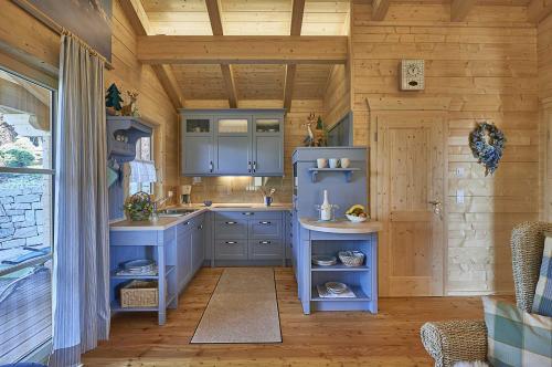 een keuken met blauwe kasten en een houten plafond bij Chalet Bergheimat in Wegscheid