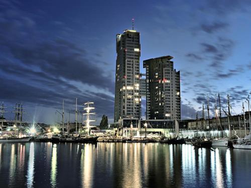 un puerto con barcos en una ciudad por la noche en Sea Towers Apartamenty, en Gdynia