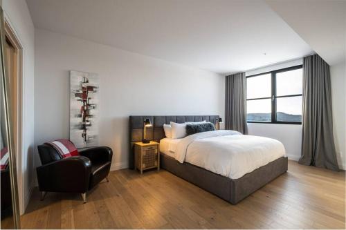 sypialnia z łóżkiem, krzesłem i oknem w obiekcie Horizon 306/Spacious Penthouse with View w mieście Mont-Tremblant