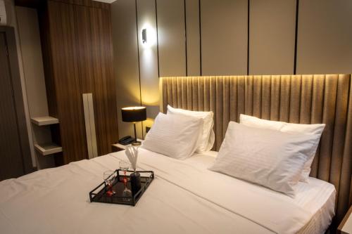 a bed with white pillows and a tray on it at Monalisa Hotels KUŞADASI in Kusadası
