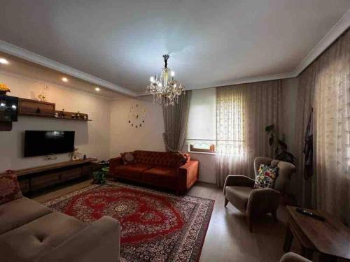 ein Wohnzimmer mit einem Sofa und einem TV in der Unterkunft Doğa içinde şehir merkezinde in Yomra