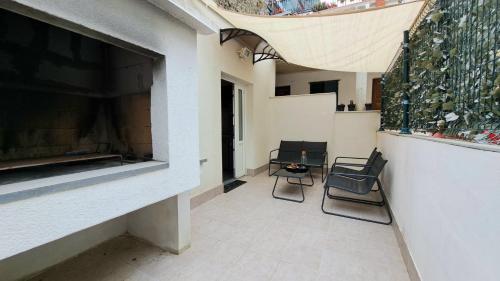 a patio with two chairs and a table in a building at Center Apartment with Terrace and Free Parking in Kaštela