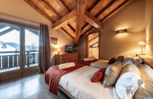 a bedroom with two beds and a large window at Chalet du Samoyède in Morzine