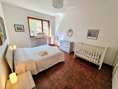 1 dormitorio con cama, cuna y ventana en Casa del tennis en Ivrea