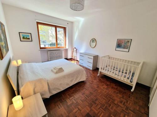 a bedroom with a bed and a crib and a window at Casa del tennis in Ivrea