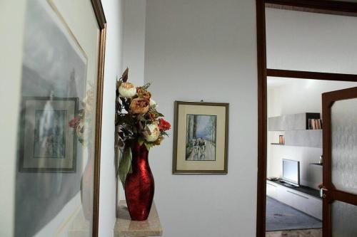 a red vase filled with flowers on a wall at Casa del tennis in Ivrea